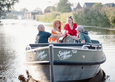 mensen proosten met wijn in een sloep