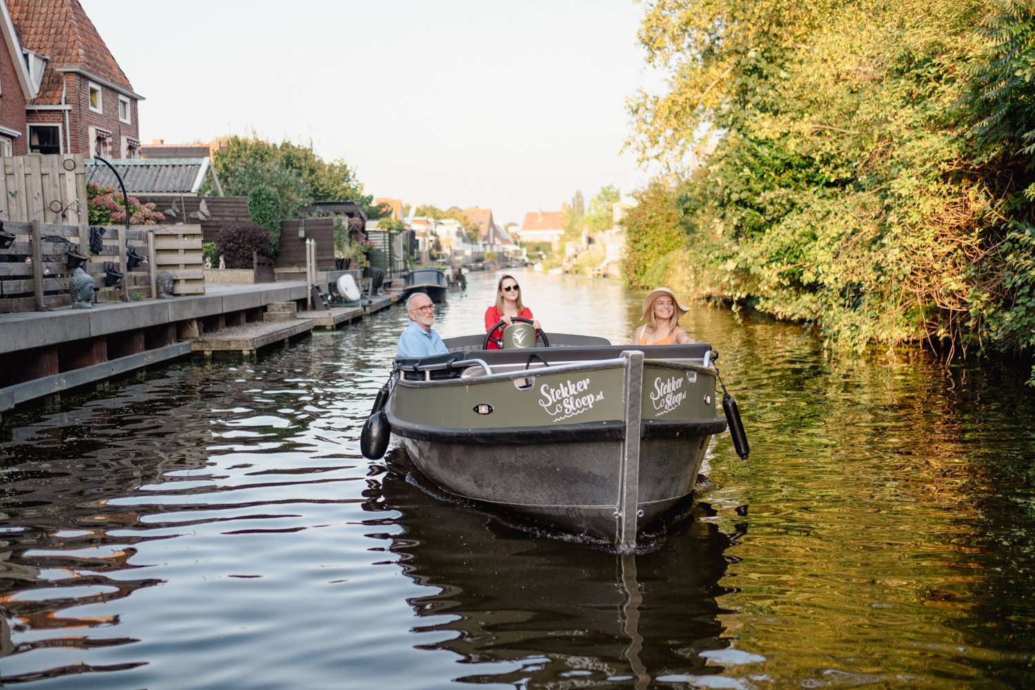 mensen in een elektrische sloep varen door het groninger landschap