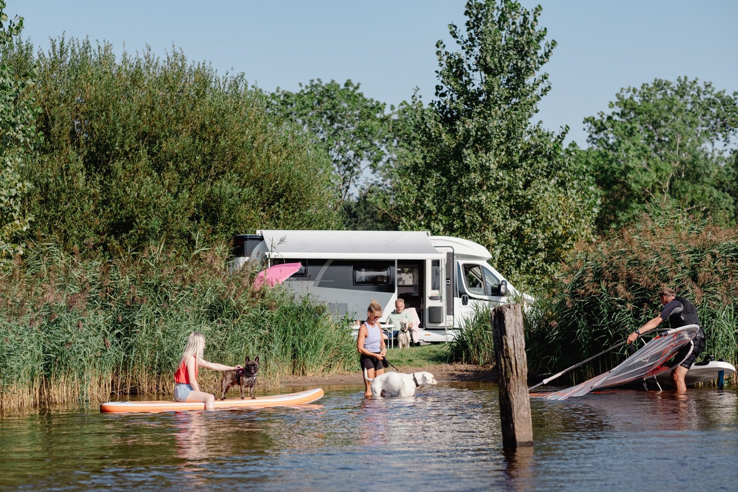 mensen op een terras aan het water met drankjes
